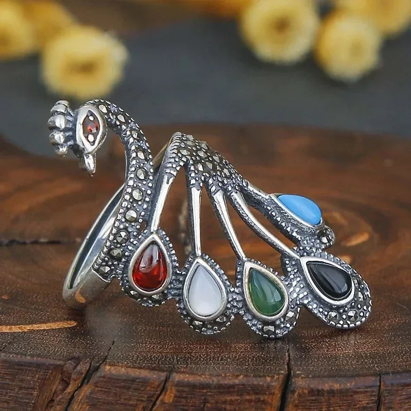 Etnický stříbrný prsten zdobený barevnými drahokamy a elegantním vzorem páva